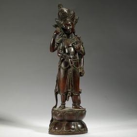 A CARVED ROSEWOOD STANDING BODHISATTVA