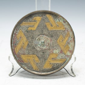 A BRONZE PARTLY GILT MIRROR