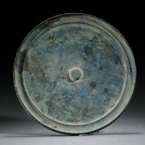 A BRONZE CIRCULAR MIRROR