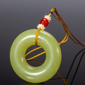 AN INSCRIBED YELLOW JADE CIRCULAR RING