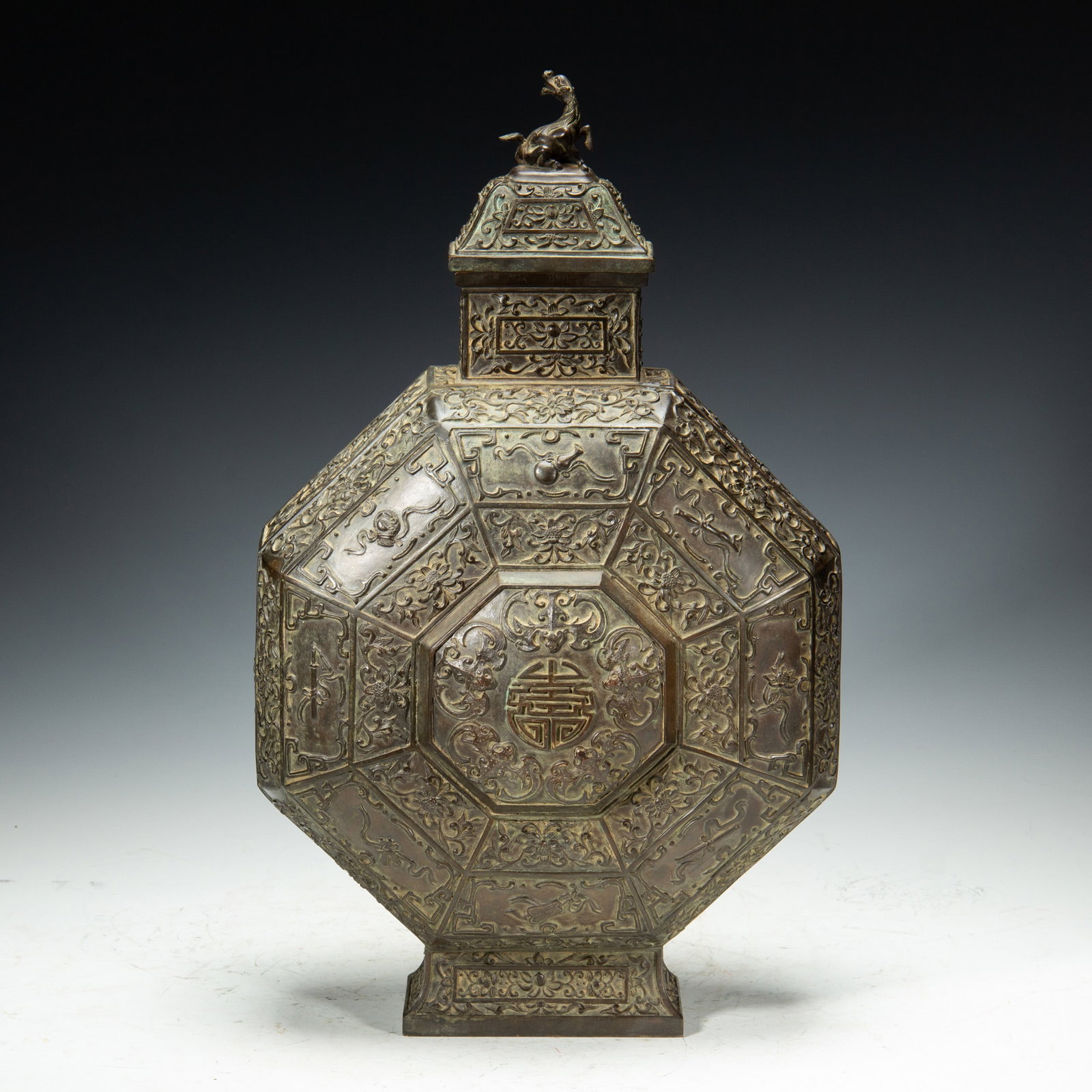 A BRONZE MOON FLASK BIANHU: A BRONZE MOON FLASK BIANHU Of flatten octagonal shape, decorated with five bats chasing longevity motif, surrounded with further auspicious symbols. Dimensions: L. 29 cm. W. 19 cm. H. 51 cm. Weight 97