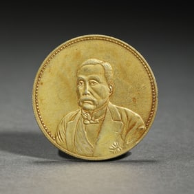 A BRONZE-GILT COIN