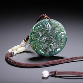 A CARVED SPINACH GREEN JADE PENDANT