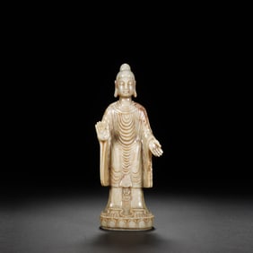 A CARVED WHITE JADE STANDING BUDDHA