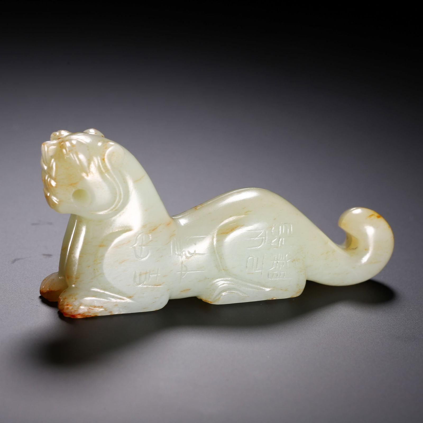 A CARVED WHITE JADE TIGER FINIAL: A CARVED WHITE JADE TIGER FINIAL Tiger-form fittings of this type were originally used as the finial on top of a bronze drum, chunyu, which served as a musical instrument to give commands to troops. L