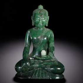 A CARVED SPINACH GREEN JADE SHAKYAMUNI