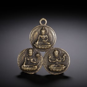 A TIBETAN BRONZE AMULET PLAQUE