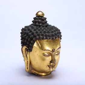A BRONZE-GILT HEAD OF BUDDHA