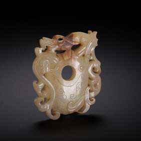 A CARVED WHITE JADE ARCHER RING SHE