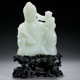 A CARVED WHITE JADE GUANYIN WITH BOY