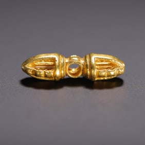 A GOLD VAJRA PENDANT