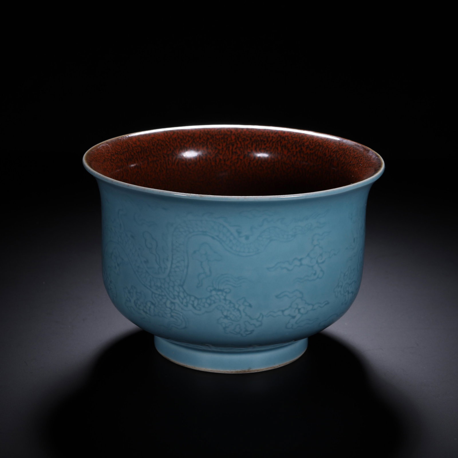 A BLUE GLAZE DRAGON BOWL: A BLUE GLAZE DRAGON BOWL The deep rounded sides rising from a circular foot to a rounded rim, incised with flying dragon among clouds, applied with sky blue glaze at the exterior, and interior glazed