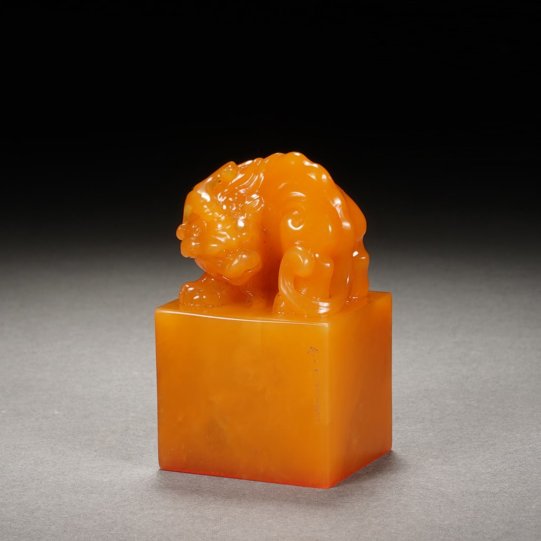 A CARVED TIANHUANG BEAST SEAL: A CARVED TIANHUANG BEAST SEAL The square-shaped seal is surmounted by a carved mythical beast finial, overall in a rich amber tone. Dimension: 3.2x2.8x5.5 cm. Weight 89 grams.