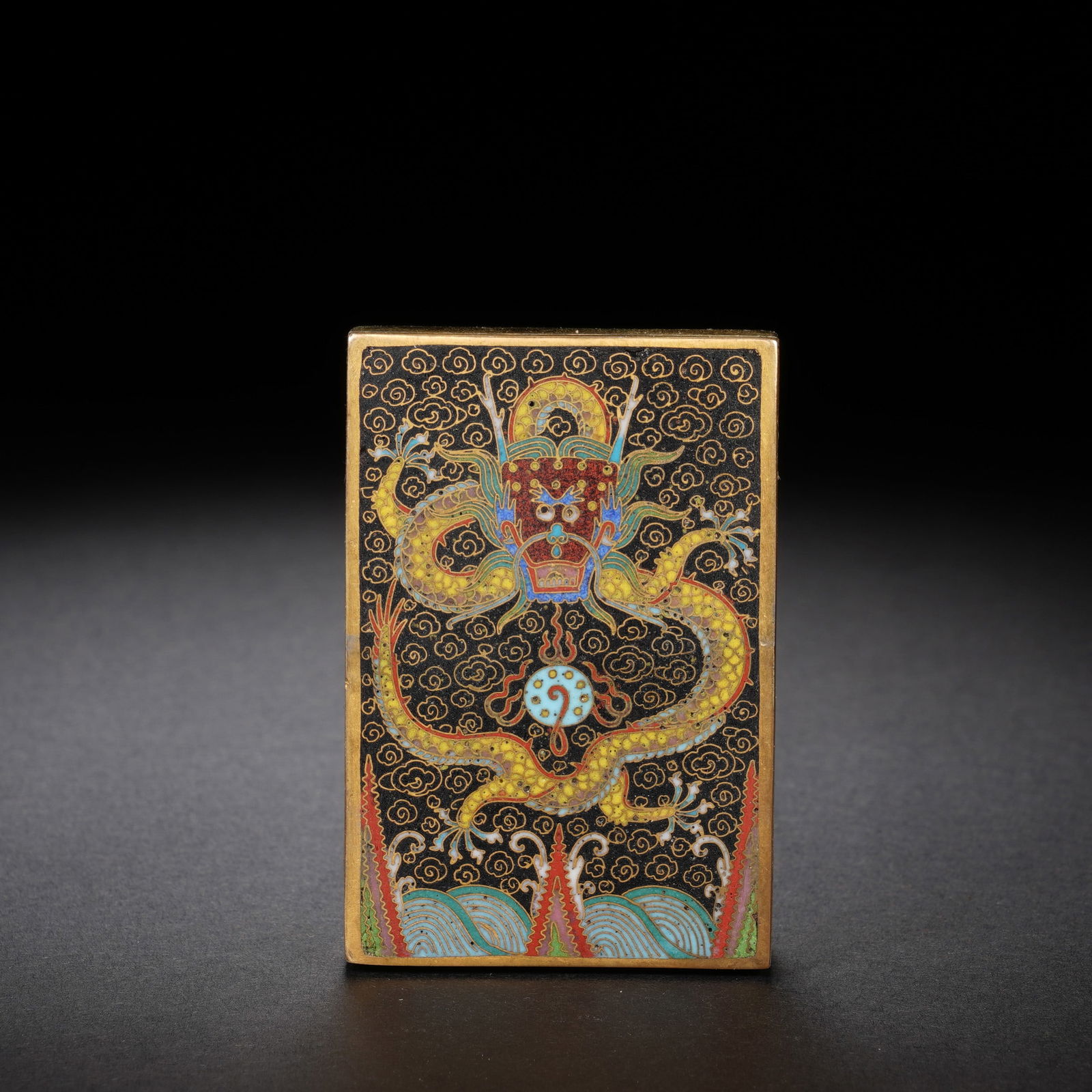 A CLOISONNE ENAMEL DRAGON PAPER WEIGHT: A CLOISONNE ENAMEL DRAGON PAPER WEIGHT Of rectangular shape, decorated with wrathful dragon chasing flaming pearl. Dimension: 4x1.9x6 cm. Weight 295 grams.