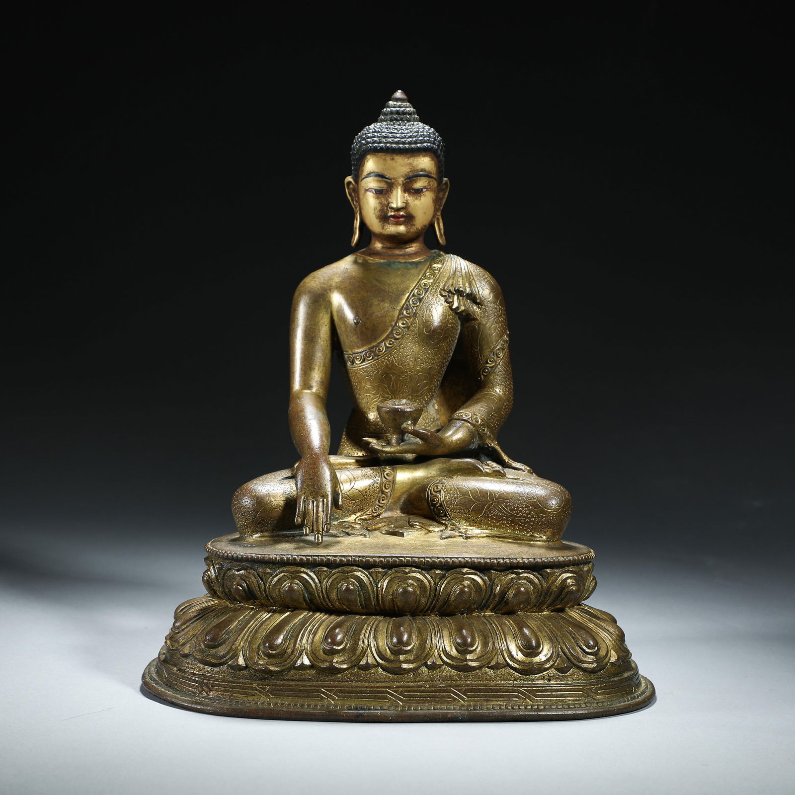 A BRONZE-GILT FIGURE OF SHAKYAMUNI (1 of 8)