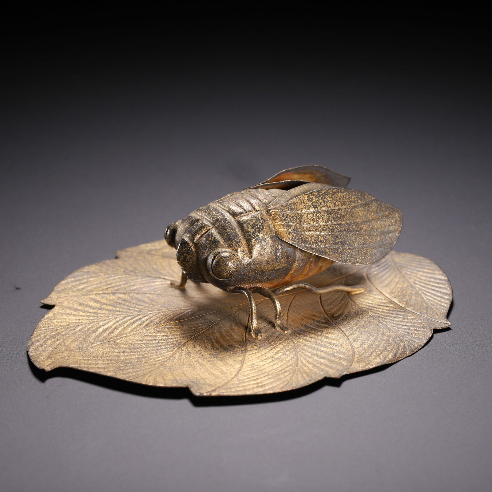 A SILVER-GILT CICADA ON LEAF: A SILVER-GILT CICADA ON LEAF Finely weaved in filigree, with surface oxidize marks. Dimension: L. 10 cm. W. 8.6 cm.
