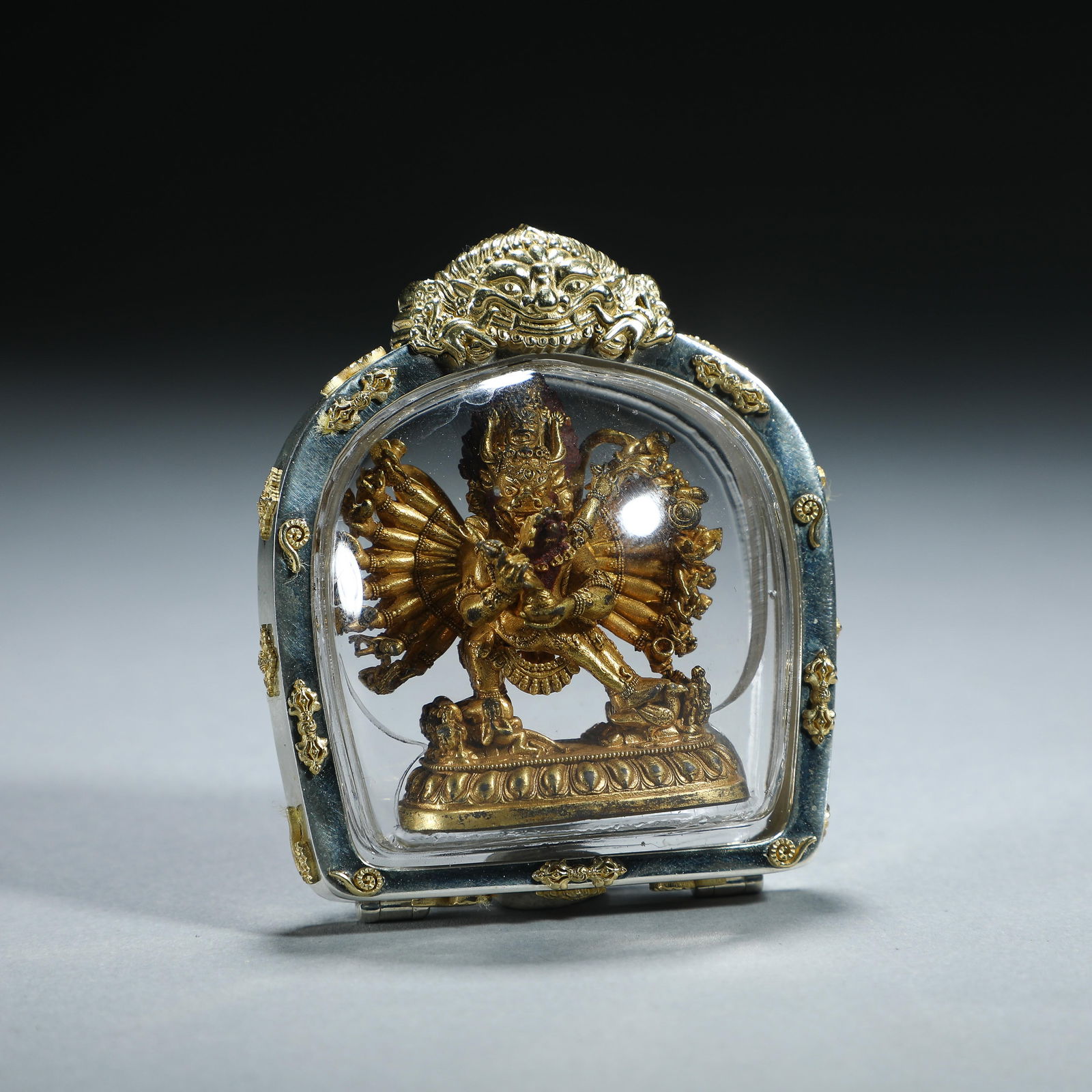 A BRONZE-GILT YAMANTAKA PENDANT: A BRONZE-GILT YAMANTAKA PENDANT Vajrabhairava Yamantaka is one of the eight protectors of Tibetan Buddhism. He is the terrifying form of Manjushri, the God of Wisdom, whose head is visible in the flam