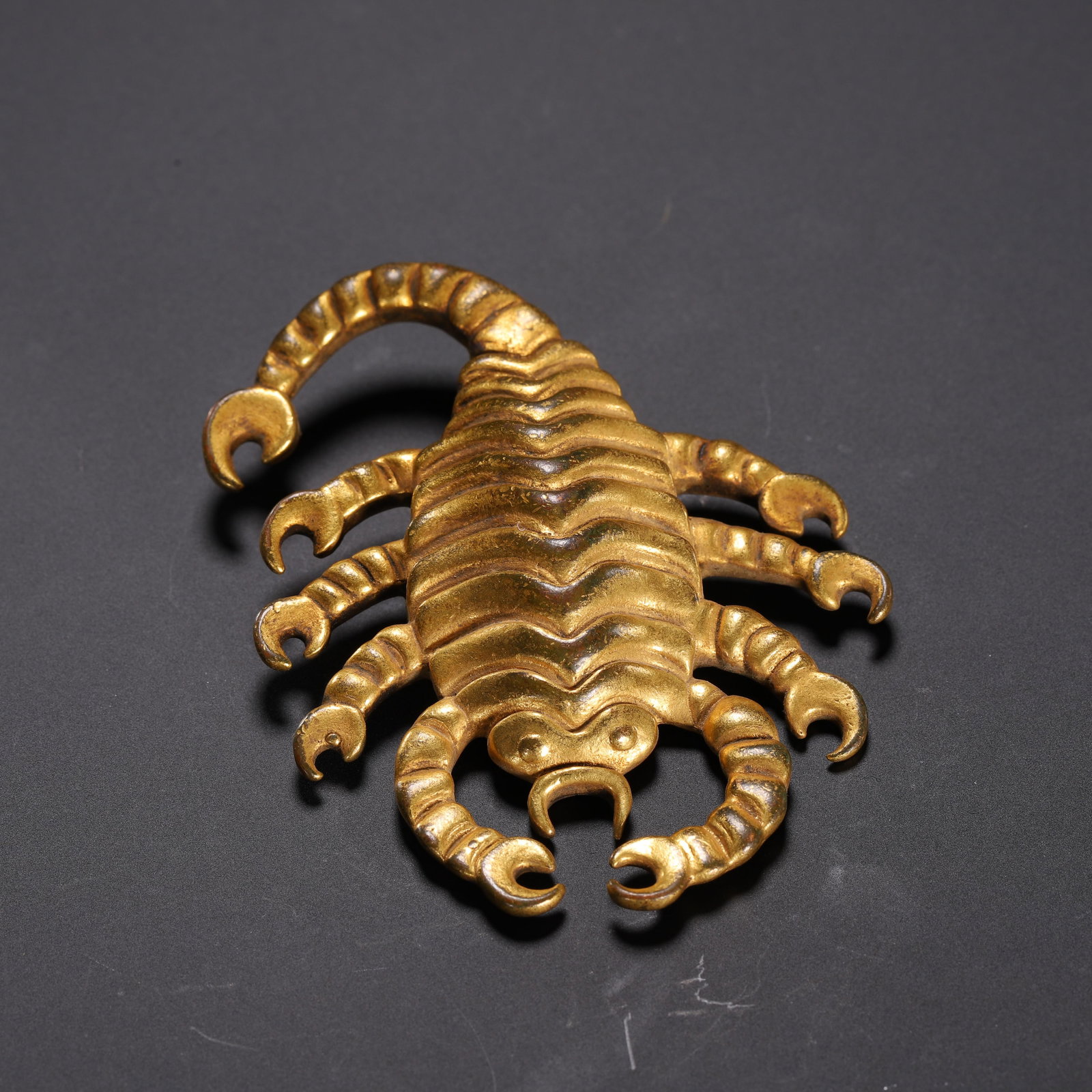 A TIBETAN BRONZE-GILT SCORPIO: A TIBETAN BRONZE-GILT SCORPIO The auspicious animal in Tibetan Buddhism. Dimension: L. 6 cm. W. 5.5 cm. Weight 40 grams.