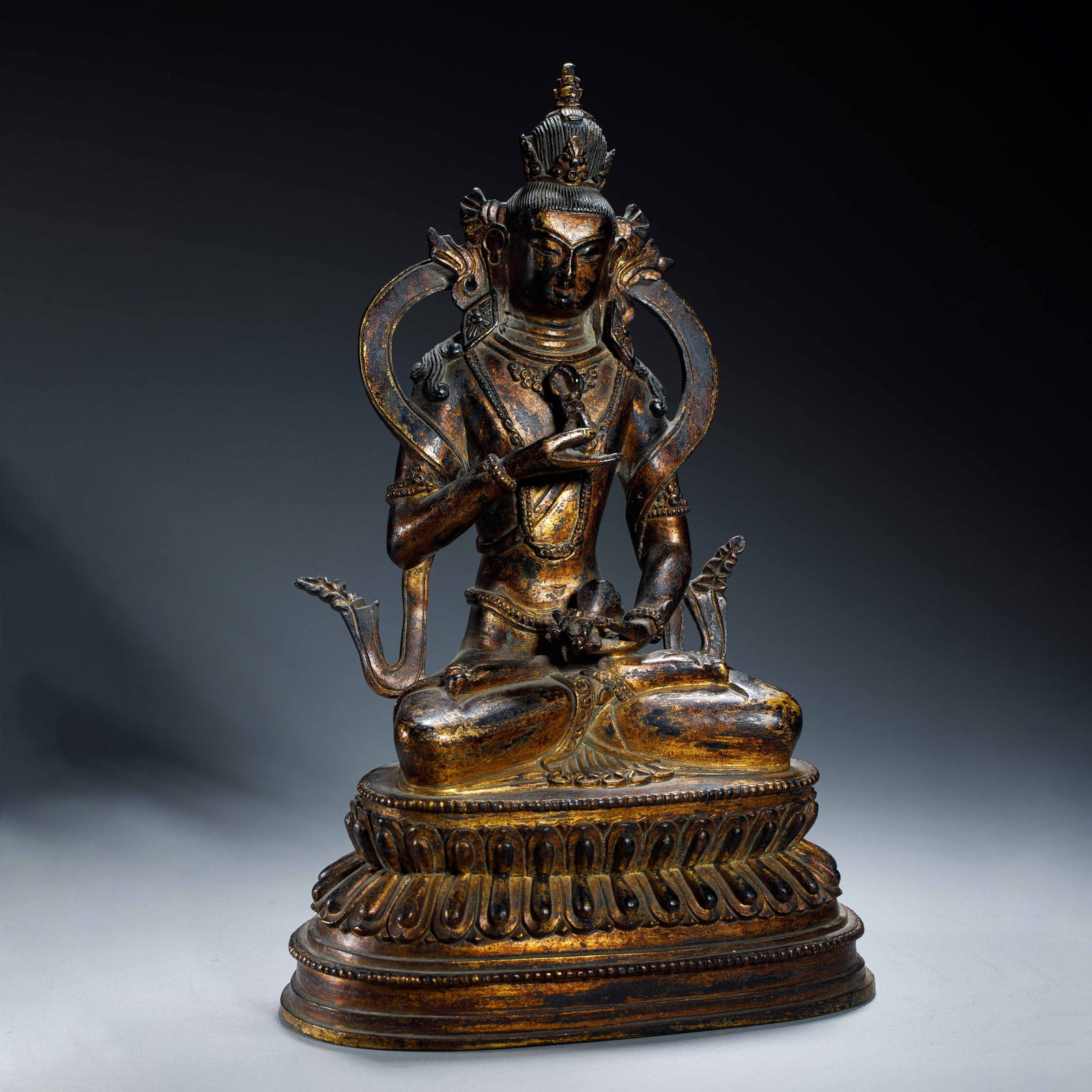 A SINO-TIBETAN BRONZE GILT VAJRASATTVA: A SINO-TIBETAN BRONZE GILT VAJRASATTVA The ‘Vajra Being’ depicted here is a primordial buddha as well as a highly-accomplished bodhisattva, with a perfected understanding of ultimate truth. He is