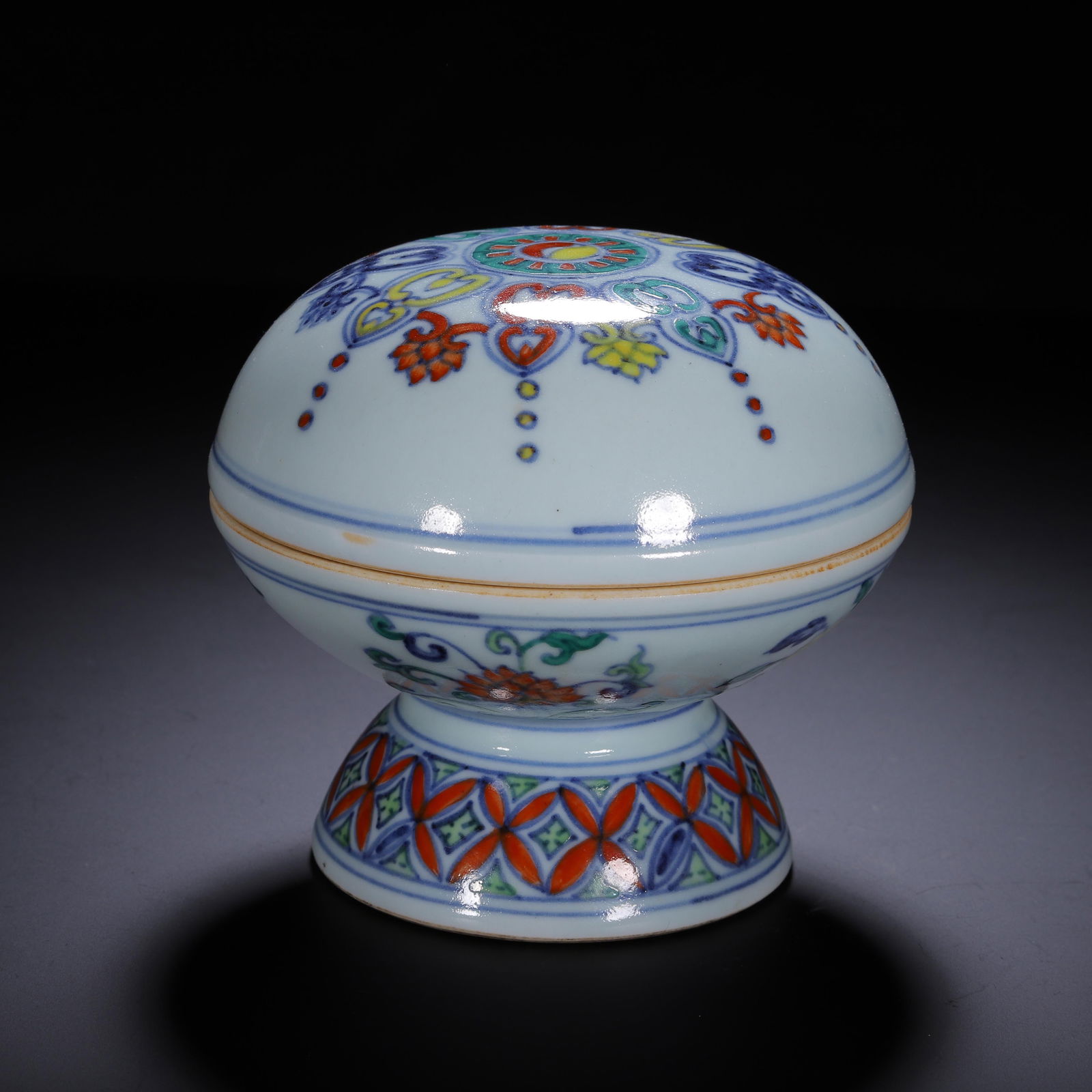 A DOUCAI GLAZE COSMETIC BOX WITH COVER: A DOUCAI GLAZE COSMETIC BOX WITH COVER Of compressed ovoid shape, decorated with lotus at the exterior. Dimension: L. 12.5 cm. W. 12.5 cm. H. 11 cm. Weight 760 grams.