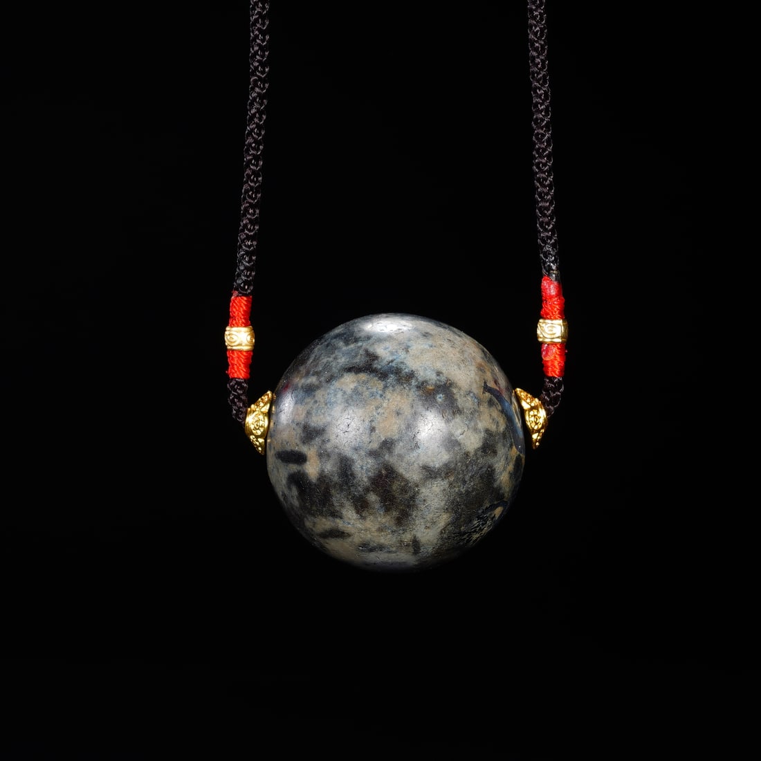 CHINESE ANTIQUE DZI BEAD PENDANT: CHINESE ANTIQUE DZI BEAD PENDANT A fine Chinese Qing dynasty antique dzi bead pendant, centered on a large spherical bead with a mottled gray-and-black natural patina, showing subtle age cracks and mi