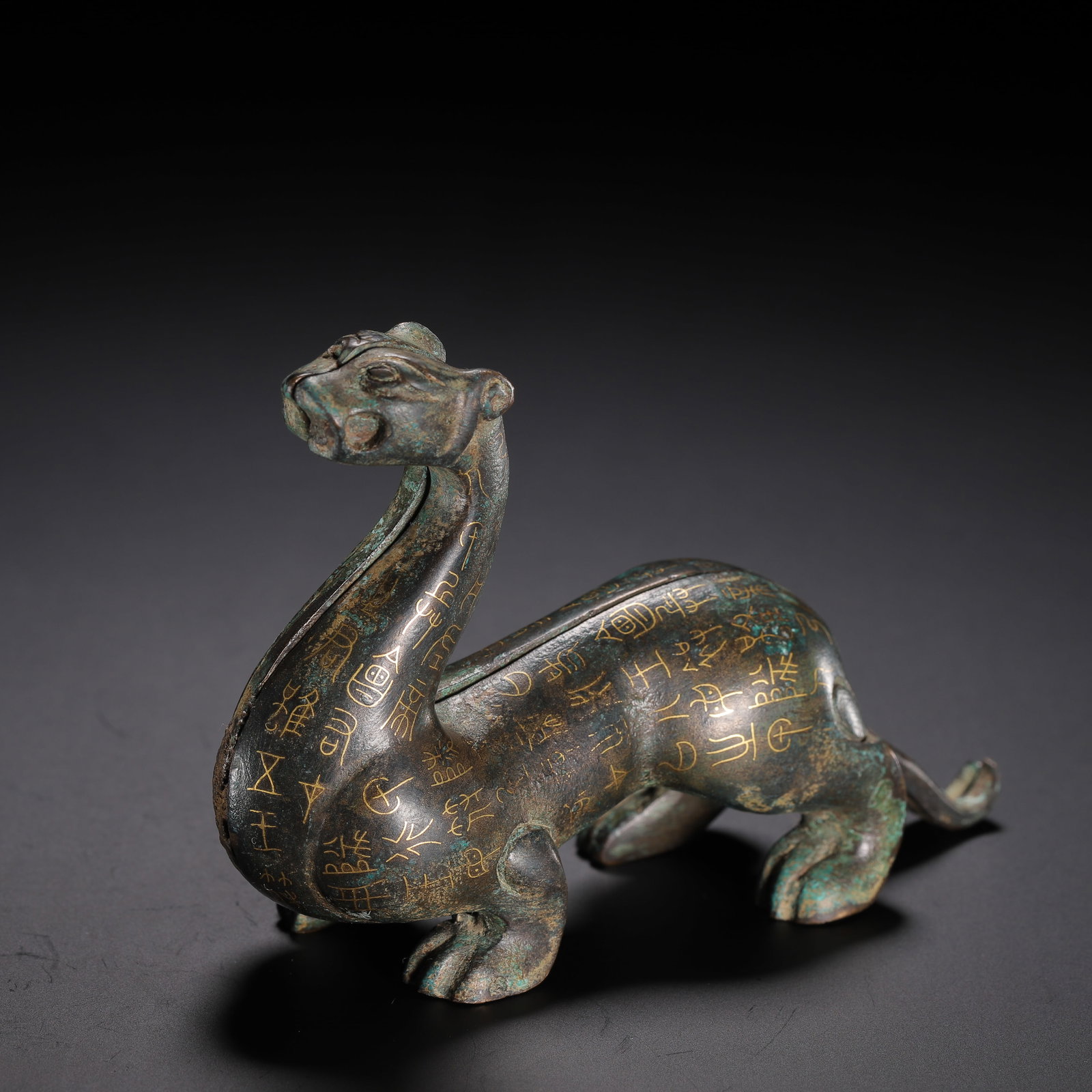 CHINESE GOLD-INLAID BRONZE BEAST TALLY: CHINESE GOLD-INLAID BRONZE BEAST TALLY A Chinese gold-inlaid bronze beast tally, measuring 10.5 cm in length, 3.5 cm in width, 7 cm in height, and weighing 450 grams. Cast in the form of a recumbent
