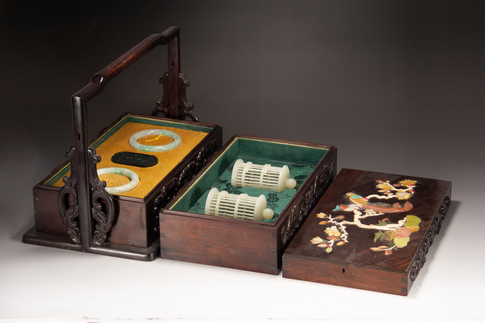 Chinese Zitan Wood Treasure Box with Inlaid Hardstones: Chinese Zitan Wood Treasure Box with Inlaid Hardstones An elaborate two-tiered zitan wood carry box, featuring a carved handle and intricate openwork carvings. The lid is adorned with a magnificent ha