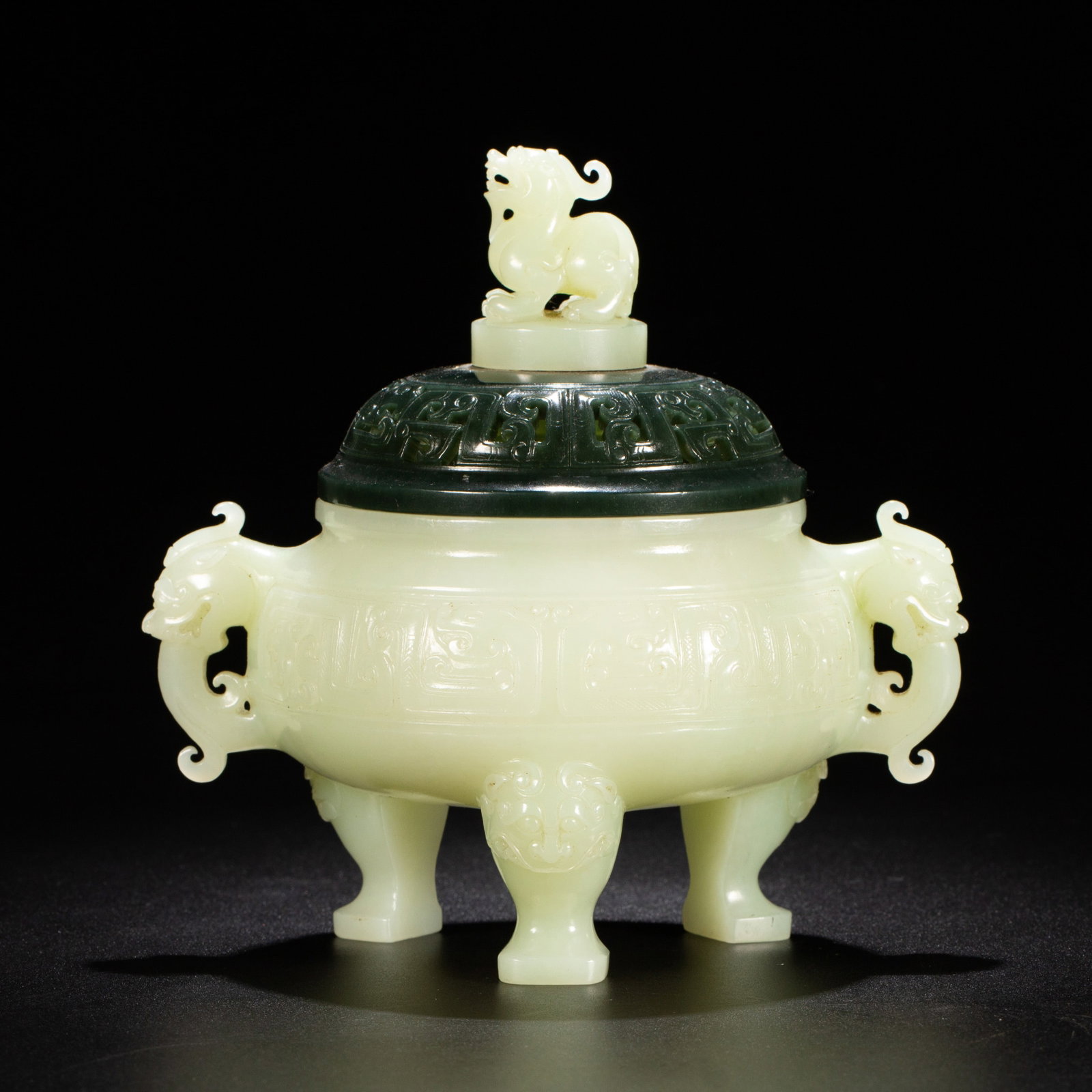 Chinese Hetian Jade Tripod Censer: Chinese Hetian Jade Tripod Censer A tripod censer crafted from fine Hetian jade, featuring a pale creamy-white body and a contrasting dark spinach jade lid. The body is adorned with carved archaic mot