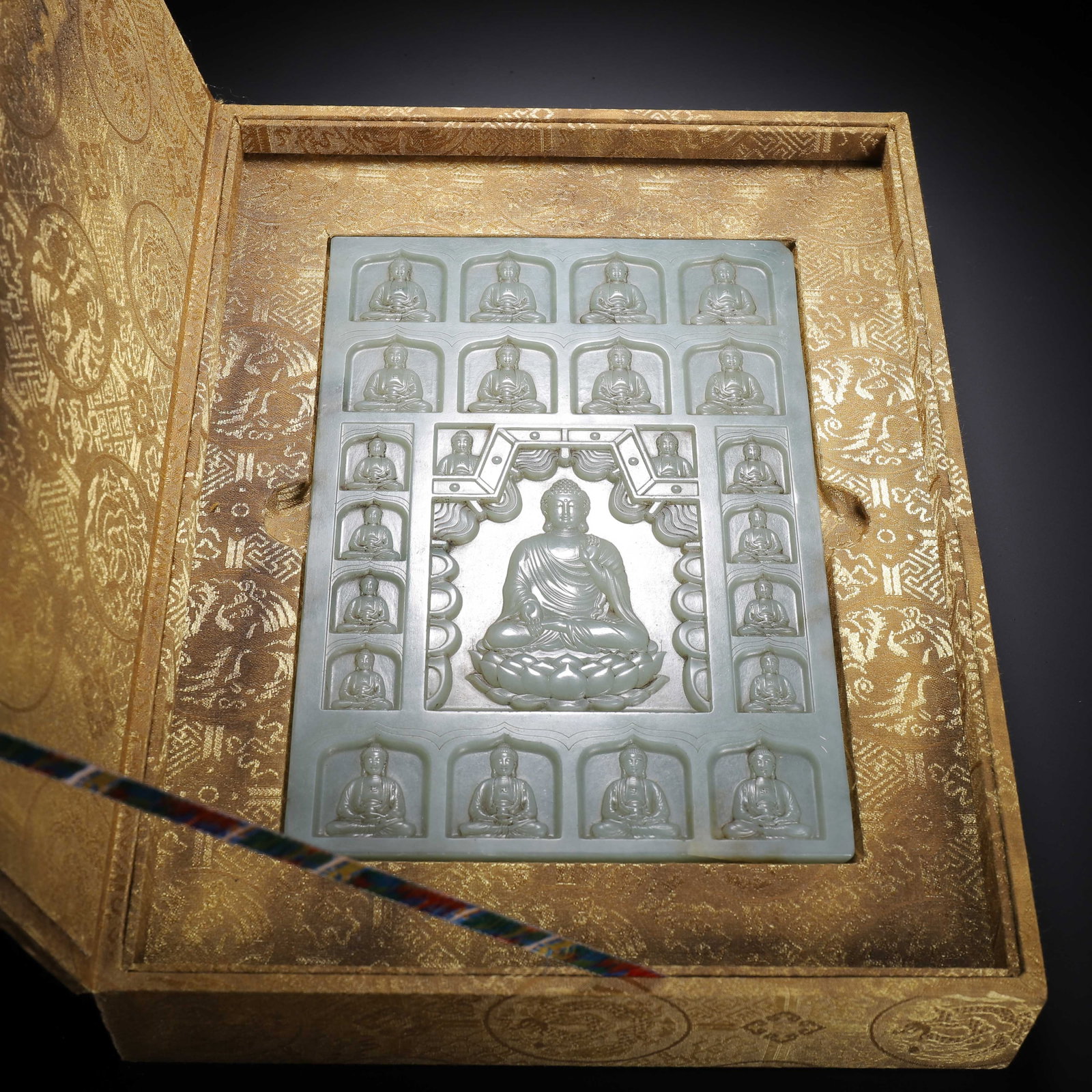 Chinese Hetian Jade Buddhist Plaque: Chinese Hetian Jade Buddhist Plaque A rectangular Hetian jade plaque carved in relief with a central seated Buddha on a lotus throne, surrounded by smaller Buddhas in niches, all framed by an ornate