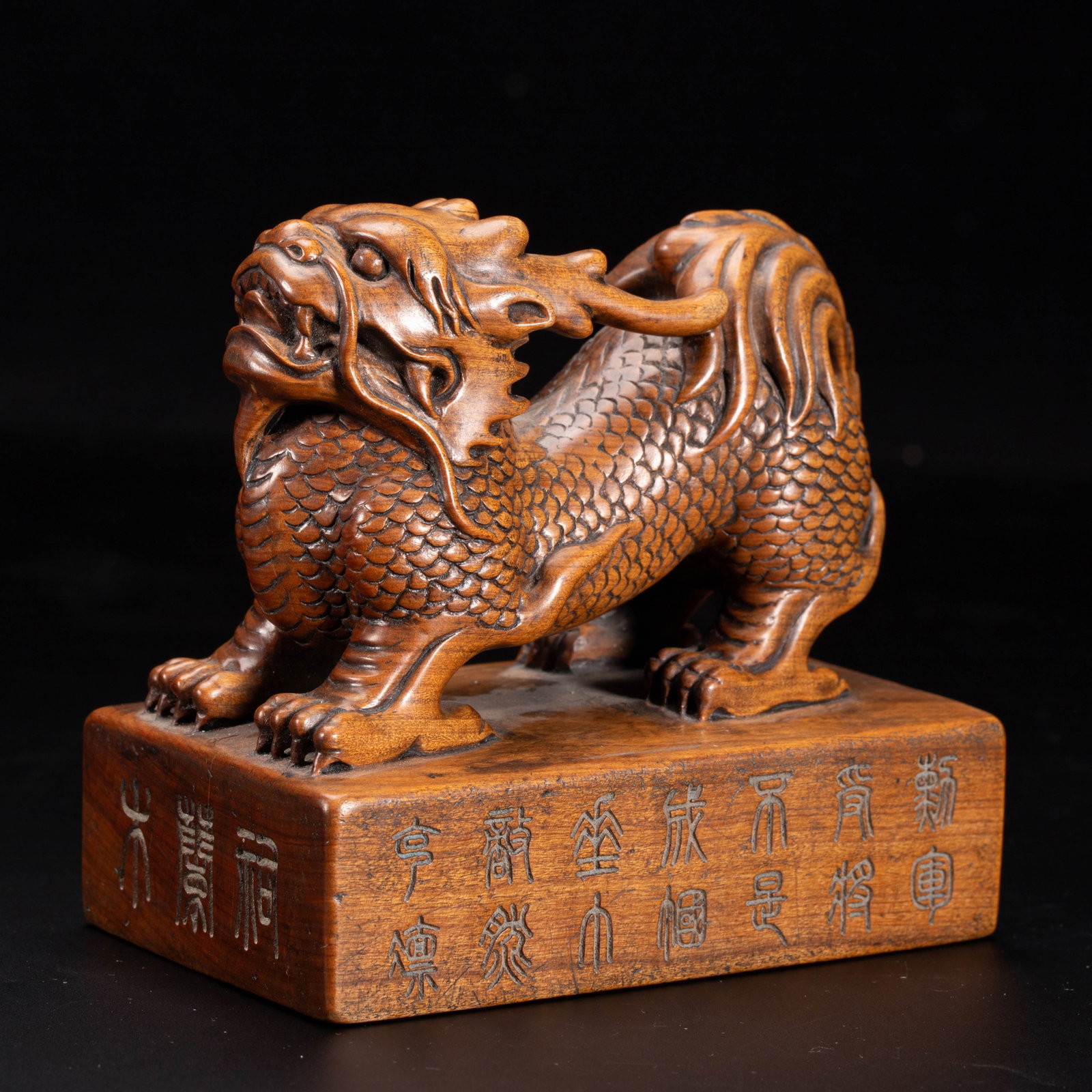 Chinese Sandalwood Auspicious Beast Seal: Chinese Sandalwood Auspicious Beast Seal A finely carved seal crafted from rich, warm-toned sandalwood, featuring a powerful qilin-like mythical beast atop a rectangular plinth. The creature is