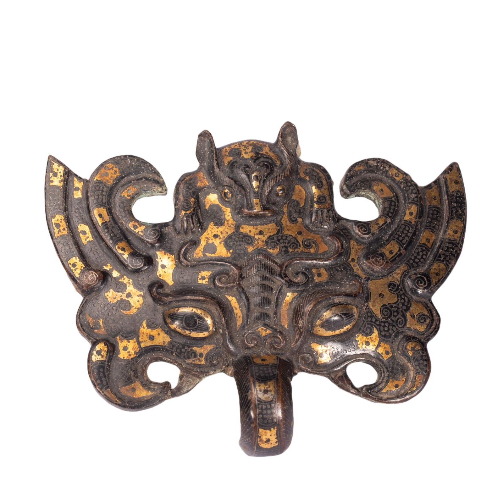 Chinese Gold and Silver Inlaid Bronze Taotie Ornament: Chinese Gold and Silver Inlaid Bronze Taotie Ornament A striking bronze ornament in the form of a taotie mask, richly adorned with elaborate gold and silver inlay against a dark patinated surface. The