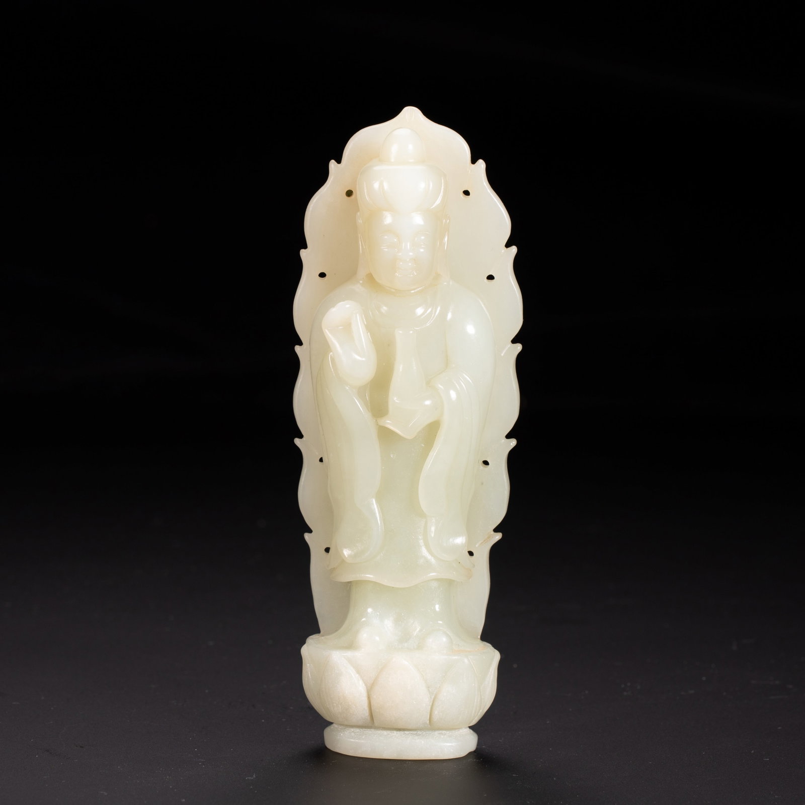 Chinese Hetian White Jade Standing Guanyin Statue: Chinese Hetian White Jade Standing Guanyin Statue A finely carved standing figure of Guanyin, crafted from smooth Hetian white jade. The bodhisattva stands serenely atop a lotus pedestal, one hand rai