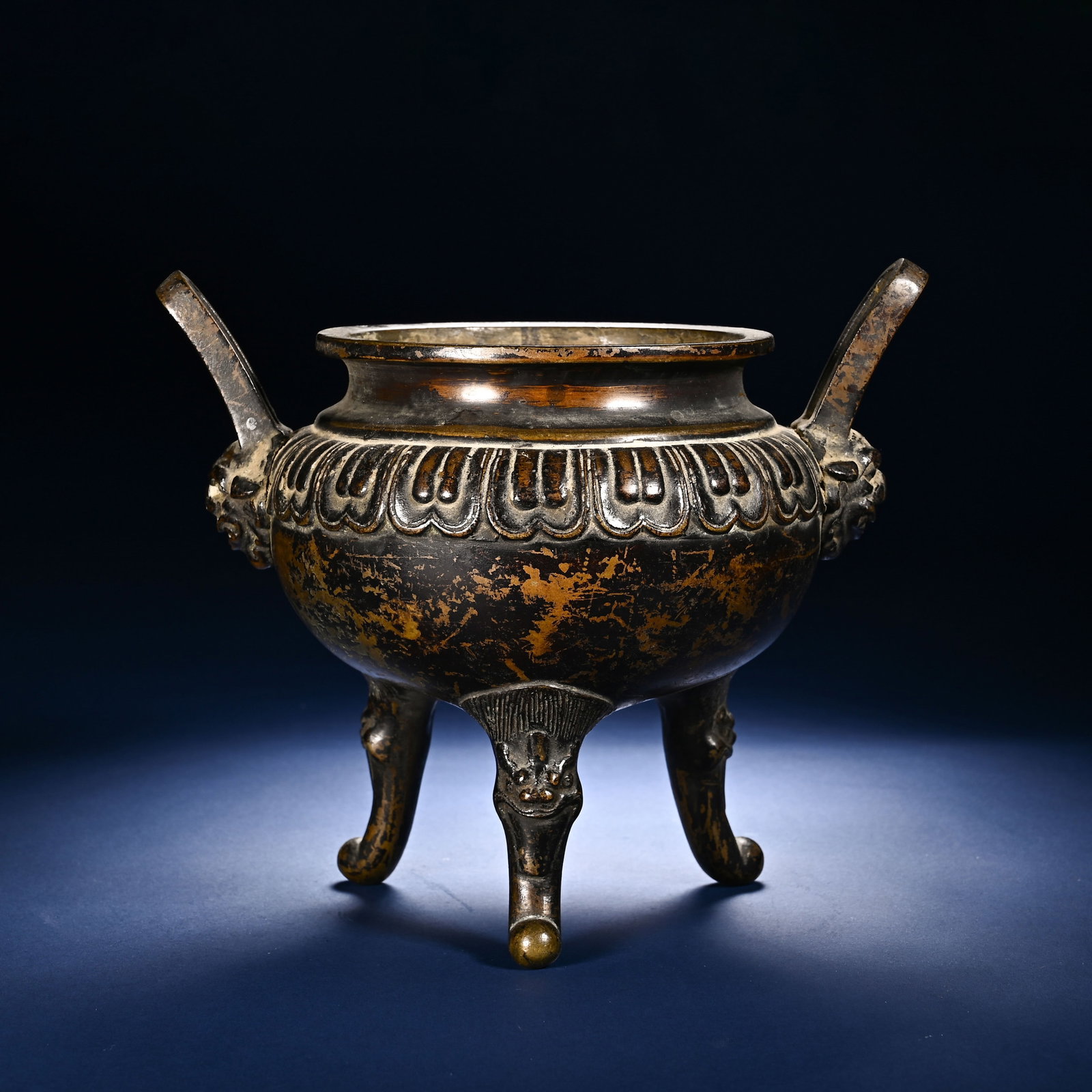 Chinese Bronze Tripod Censer with Mask Handles: Chinese Bronze Tripod Censer with Mask Handles This stately bronze tripod censer measures 14.5 cm in height and 17.5 cm in width. The rounded body is encircled by a band of raised lotus petal motifs j