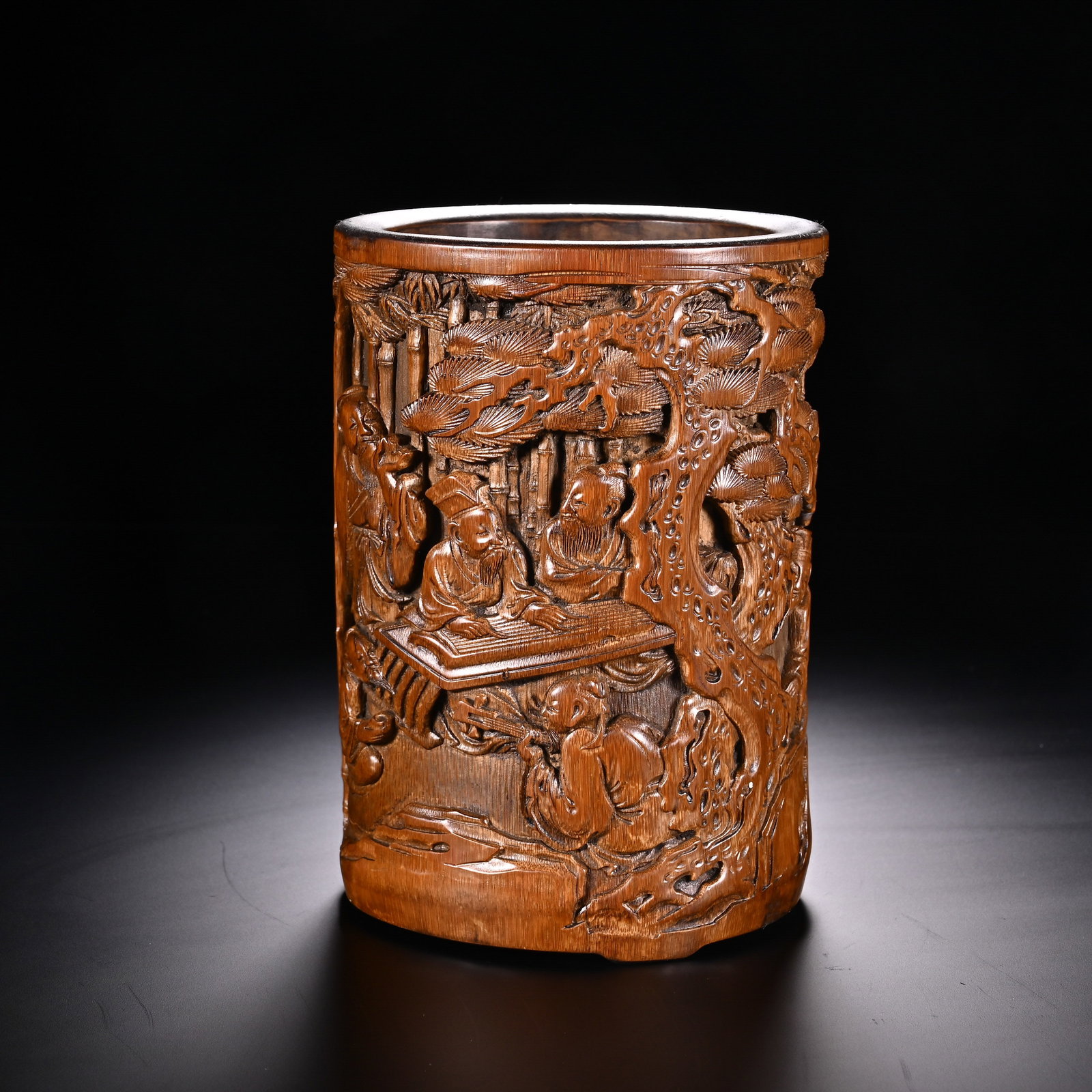 Chinese Bamboo Carved Brush Pot with 'Scholars in a Garden' Scene: Chinese Bamboo Carved Brush Pot with 'Scholars in a Garden' Scene This cylindrical bamboo brush pot measures 13.7 cm in height and 9.7 cm in width. Its exterior is deeply carved in relief with an elab