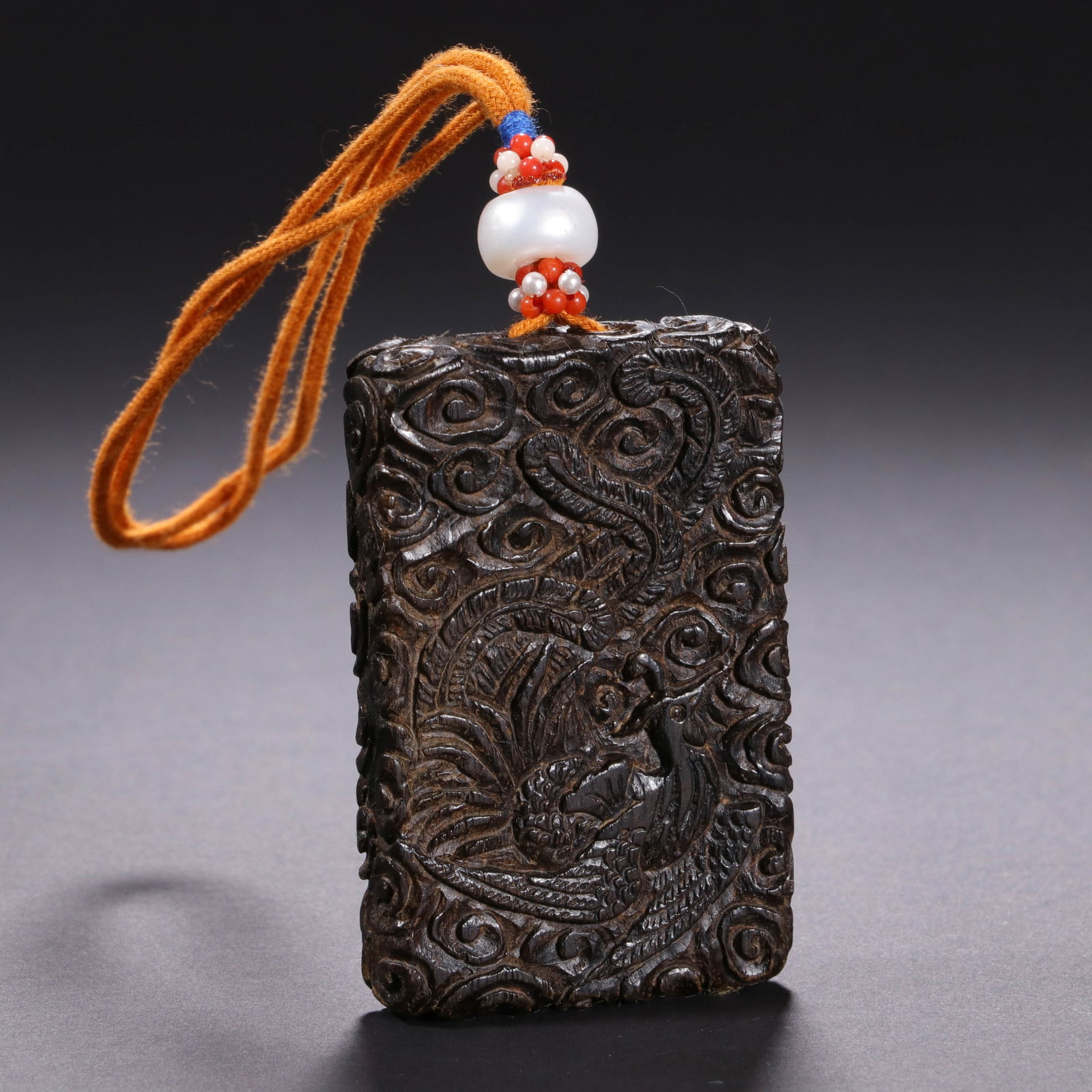 Chinese Agarwood Phoenix Pendant Plaque: Chinese Agarwood Phoenix Pendant Plaque This finely carved agarwood pendant plaque measures 6.1 cm in length and 3.9 cm in width. The dark, richly grained wood is deeply carved with a phoenix motif su