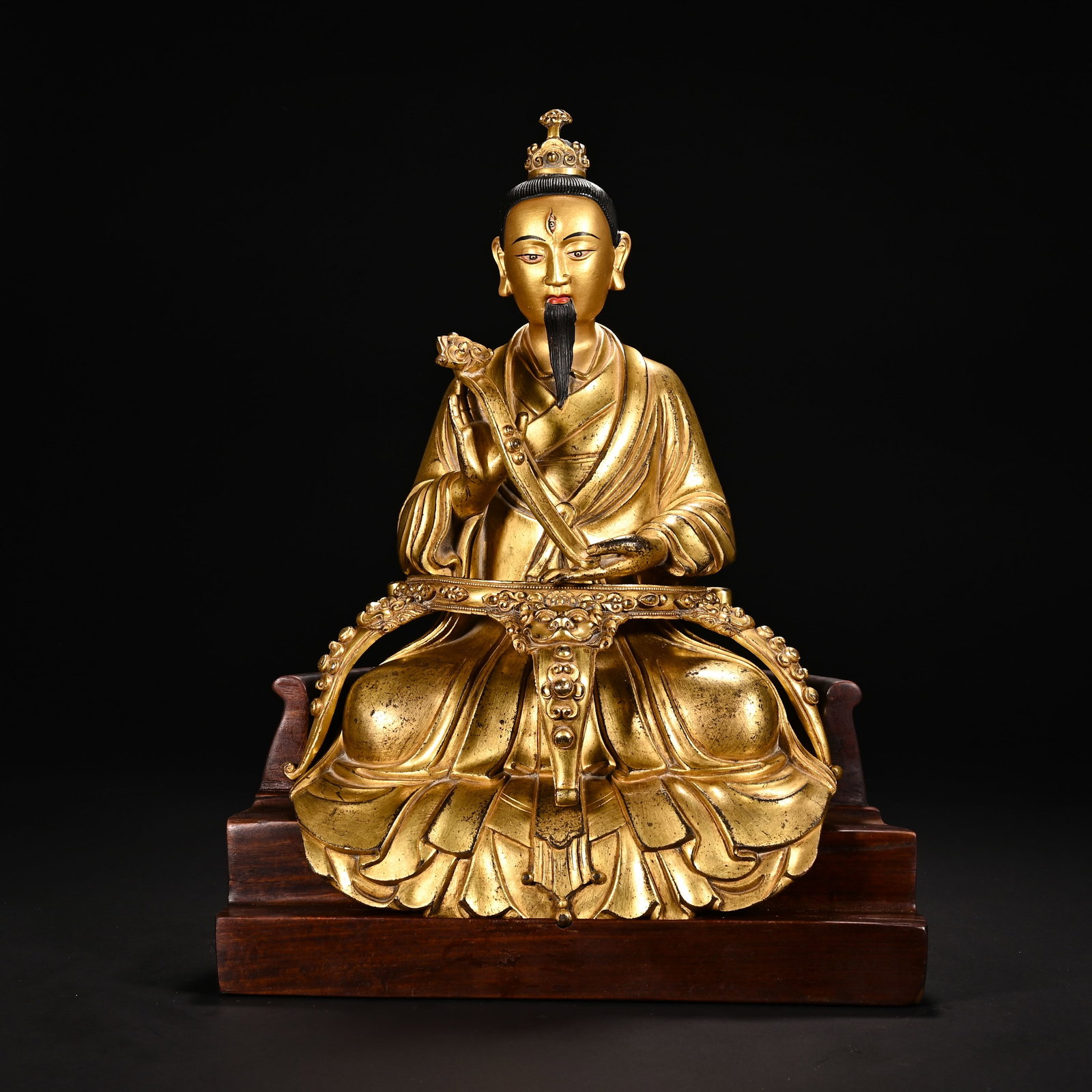 Chinese Gilt Bronze Taoist Immortal Statue: Chinese Gilt Bronze Taoist Immortal Statue This finely crafted gilt bronze Taoist immortal statue measures 33 cm in height and 24 cm in width. The figure is depicted seated in a formal pose atop a cus