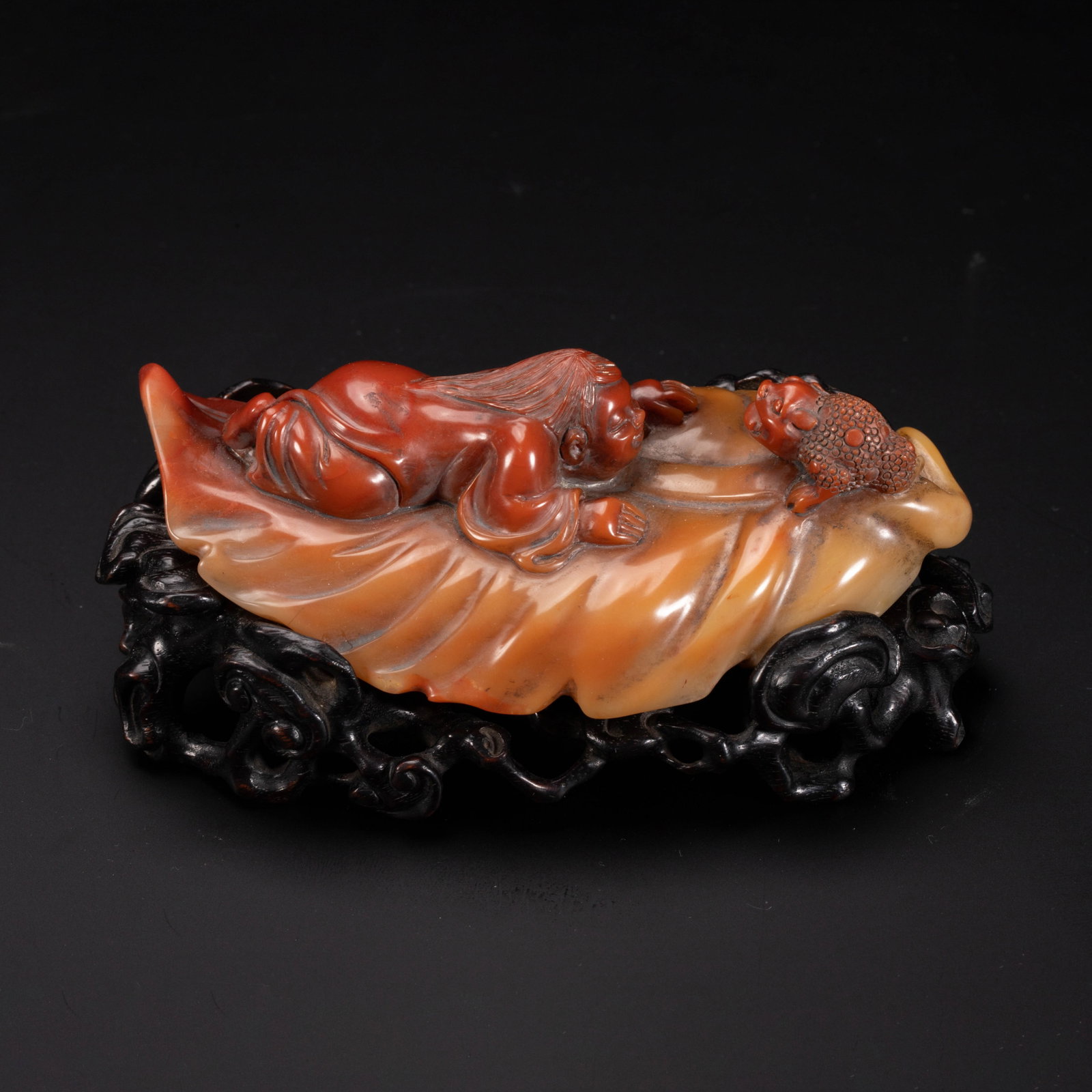 Chinese Shoushan Stone "Liu Hai and Toad" Water Dropper: Chinese Shoushan Stone "Liu Hai and Toad" Water Dropper A finely carved water dropper crafted from multi-toned Shoushan stone, depicting the playful scene of Liu Hai reclining on a large leaf,