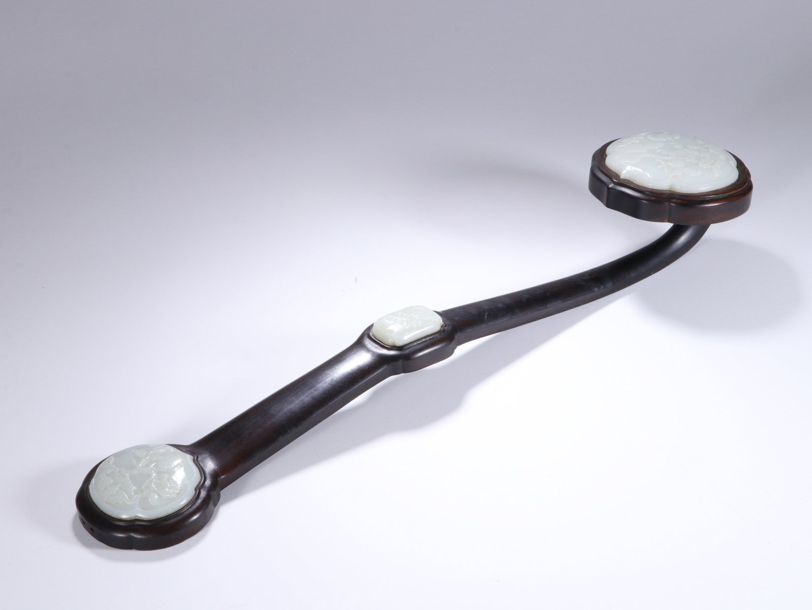 Chinese Zitan Wood Ruyi Scepter with Three White Jade Insets: Chinese Zitan Wood Ruyi Scepter with Three White Jade Insets This elegant ruyi scepter measures 47 cm in length. The smooth, polished dark zitan wood shaft is inlaid with three finely carved white