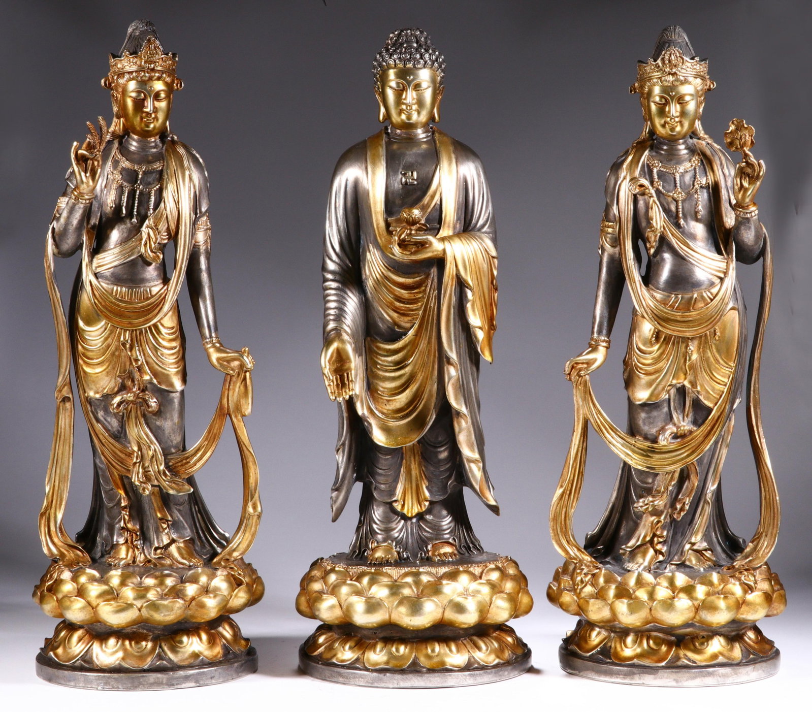 Set of Three Chinese Silver-Gilt Buddhist Statues: Set of Three Chinese Silver-Gilt Buddhist Statues This magnificent set of three silver-gilt Buddhist statues stands at 47 cm in height and 17 cm in width each. The central figure depicts the Buddha,