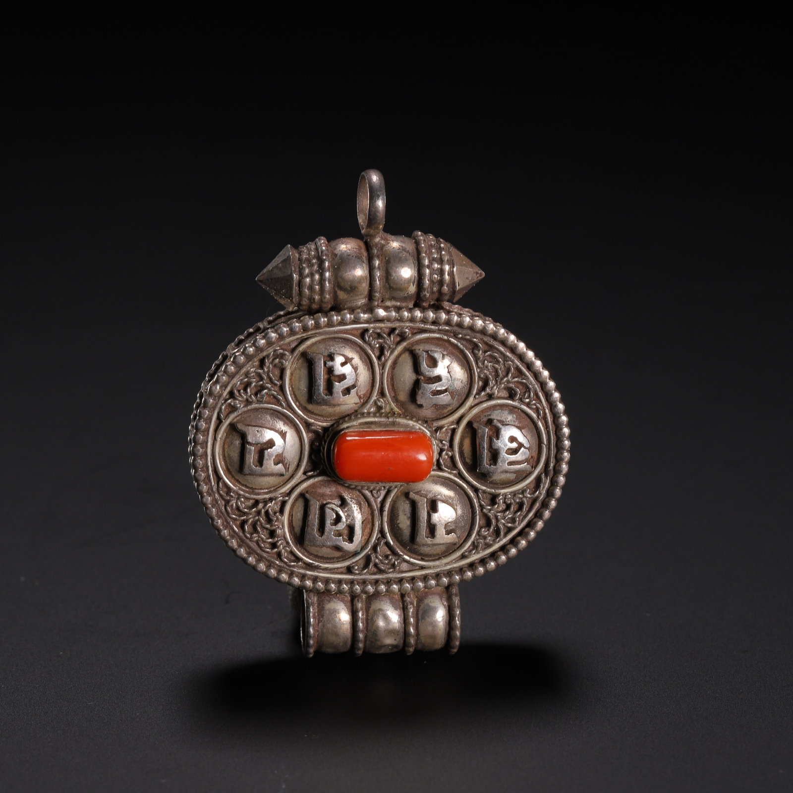 Chinese Tibetan Silver Gau Pendant with Coral and Mantras: Chinese Tibetan Silver Gau Pendant with Coral and Mantras An ornate Tibetan silver gau pendant, crafted to hold sacred relics. The circular front panel features six raised silver discs engraved with B