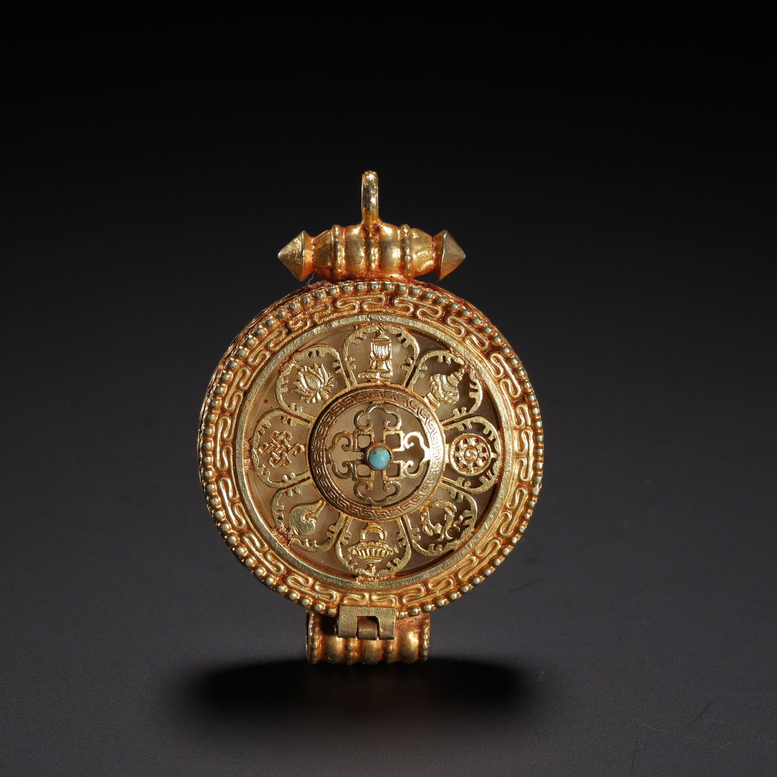 Chinese Tibetan Gilded Silver Gau Pendant with Turquoise and Ashtamangala: Chinese Tibetan Gilded Silver Gau Pendant with Turquoise and Ashtamangala A finely crafted Tibetan gilded silver gau pendant, designed as a portable shrine for sacred relics. The circular front featur