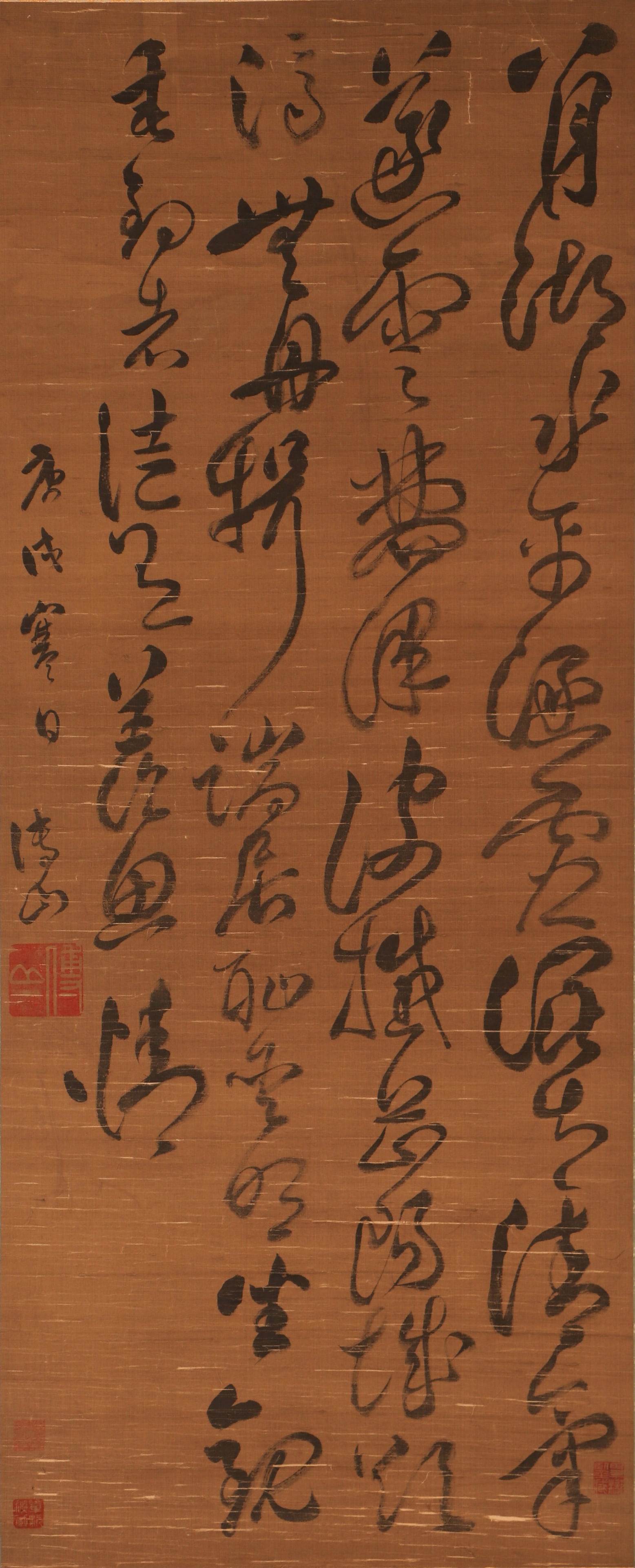 A CHINESE CALLIGRAPHY WORK, SIGNED FU SHAN: A CHINESE CALLIGRAPHY WORK, SIGNED FU SHAN This hanging scroll features bold cursive script calligraphy by the Ming-Qing dynasty master Fu Shan, rendered in ink on aged silk. The work exemplifies his