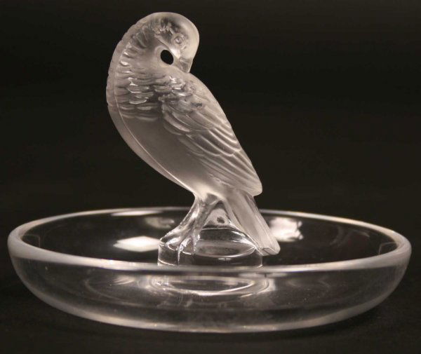A Small Lalique Pin/Ash Tray. The round clear-gla: A Small Lalique Pin/Ash Tray. The round clear-glass dish centred by a frosted glass bird and signed on base Lalique France, 3 ins (8 cms) in height, 3½ ins (9 cms) in diameter.