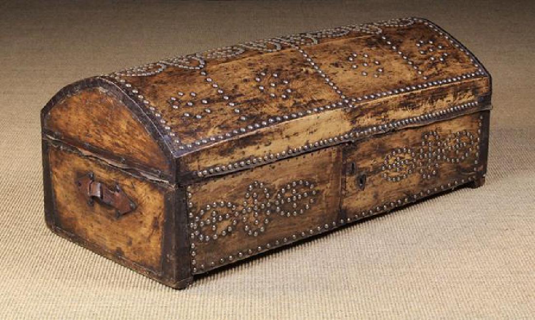 An 18th/19th Century Dome-topped Leather Clad Chest: An 18th/19th Century Dome-topped Leather Clad Chest adorned with brass studs. The ends with leather strap handles. The interior lined in decorative printed fabric. 15 in (38 cm) high, 37½ in (95 cm)
