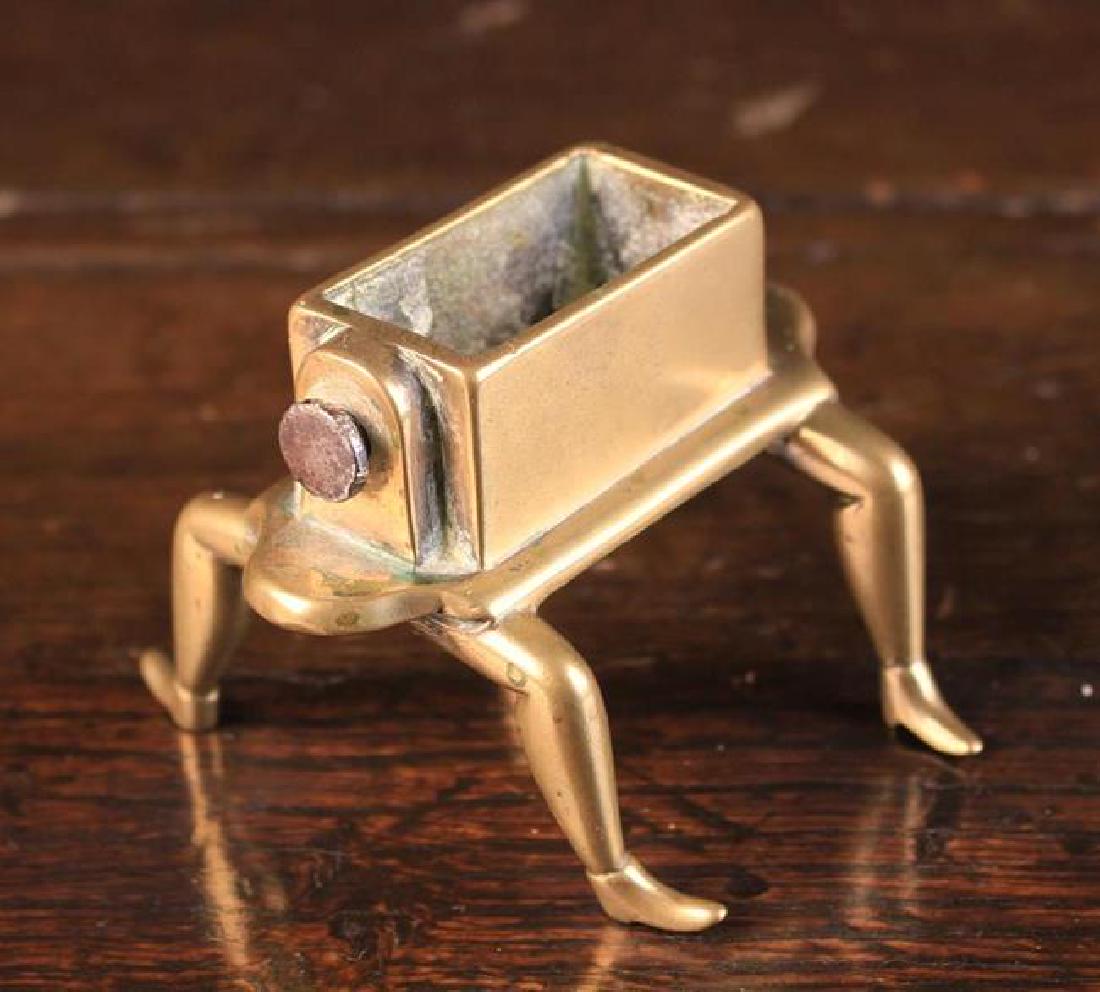 A Rare Late 18th Century Brass Pen-nib Washer having a: A Rare Late 18th Century Brass Pen-nib Washer having a rectangular trough with screw-clamp fastener to one end, standing on four human style legs 2½'' (6.5 cm) high, 3½'' (9 cm) wide, 3½'' (9 cm) d