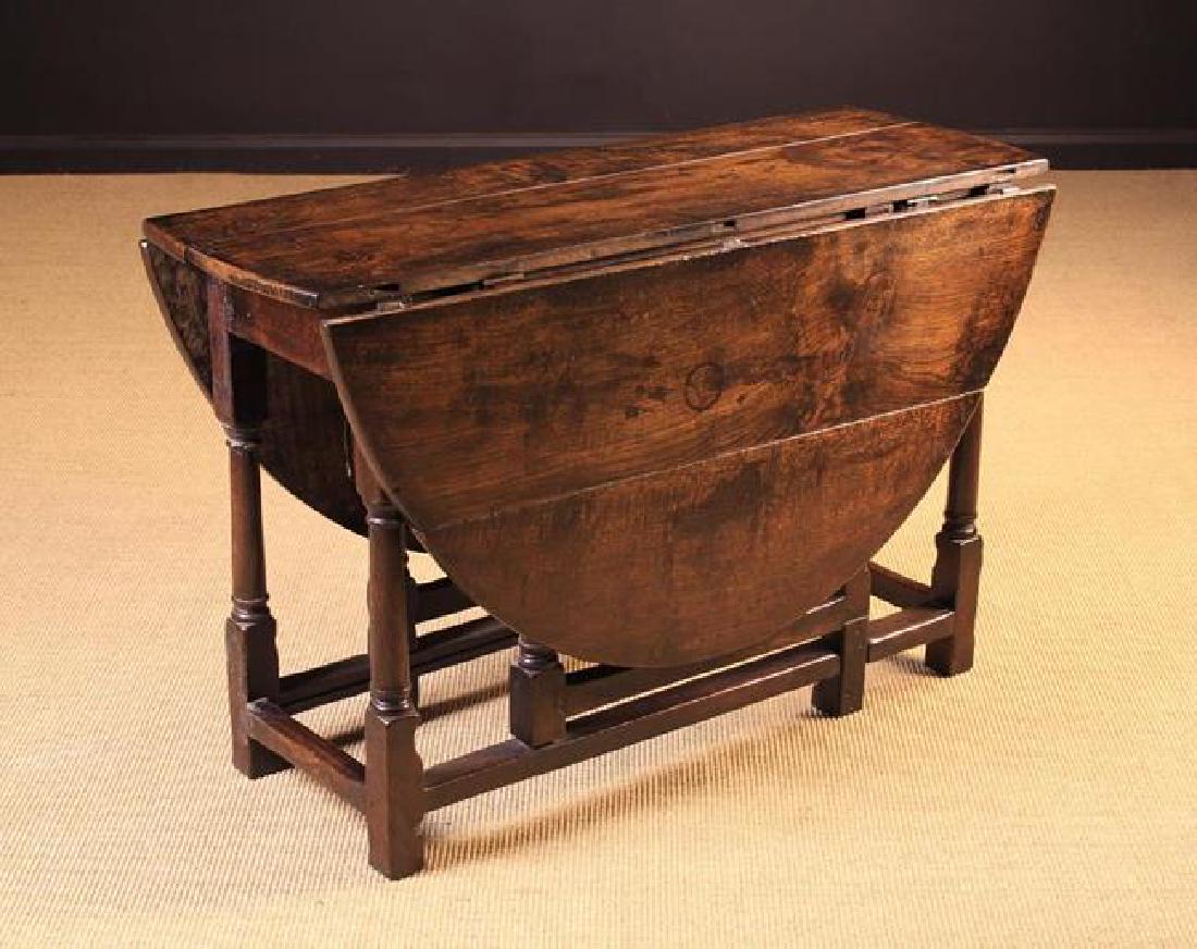 An Late 17th/Early 18th Century Joined Oak Gateleg: An Late 17th/Early 18th Century Joined Oak Gateleg Table. The oval top with drop leaves on turned columnar legs & gates united by peripheral stretchers. One end fitted with a drawer. 26½'' (68 cm) hi