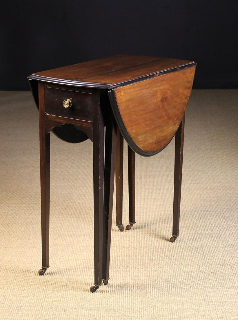 A Small Edwardian Red Walnut Drop Leaf Table. The oval: A Small Edwardian Red Walnut Drop Leaf Table. The oval top having a moulded edge standing on square tapering legs with ceramic castors, and fitted with a small drawer to one end. 30 in (76 cm) high, 2