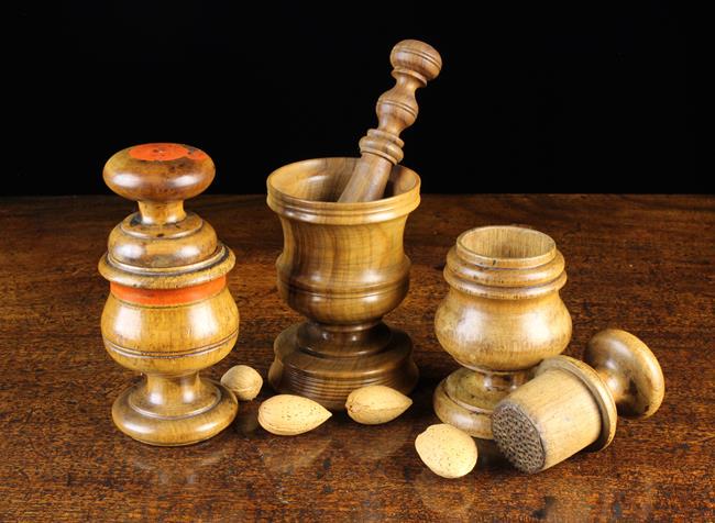 Two 19th Century Mortar Graters; one decorated with a: Two 19th Century Mortar Graters; one decorated with a red painted border band, approx 5½'' (14 cm) in height, and a turned olive wood pestle & mortar; the pestle 5'' (13 cm) in length, the camp