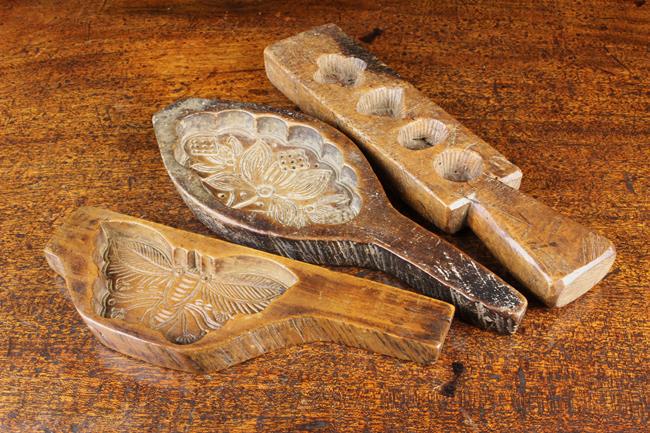 Three 19th Century Carved Treen Biscuit Moulds: One: Three 19th Century Carved Treen Biscuit Moulds: One carved with a rare butterfly design 8¼'' (21 cm) in length. One for petit fours 10'' (25.5 cm) in length. The third carved with flowers and f