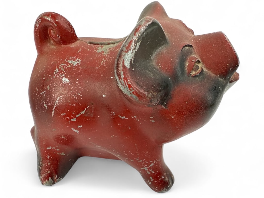 Cast Piggy Bank By Standard Federal, Detroit: Cast metal piggy bank in the form of a red pig. Measures 5" x 3.25" x 4" high. Features a coin slot on the back and locking mechanism on the bottom marked "Standard Federal Savings And Loan Associatio
